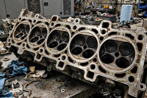 Removed diesel engine cylinder head showing the head gasket sealing surface in a generator service bay